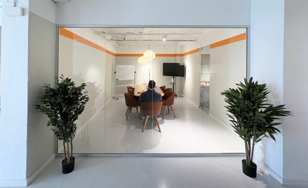 Sala de reuniones de cristal en una oficina moderna, reflejando una cultura de empresa transparente que ayuda a la retención de talento