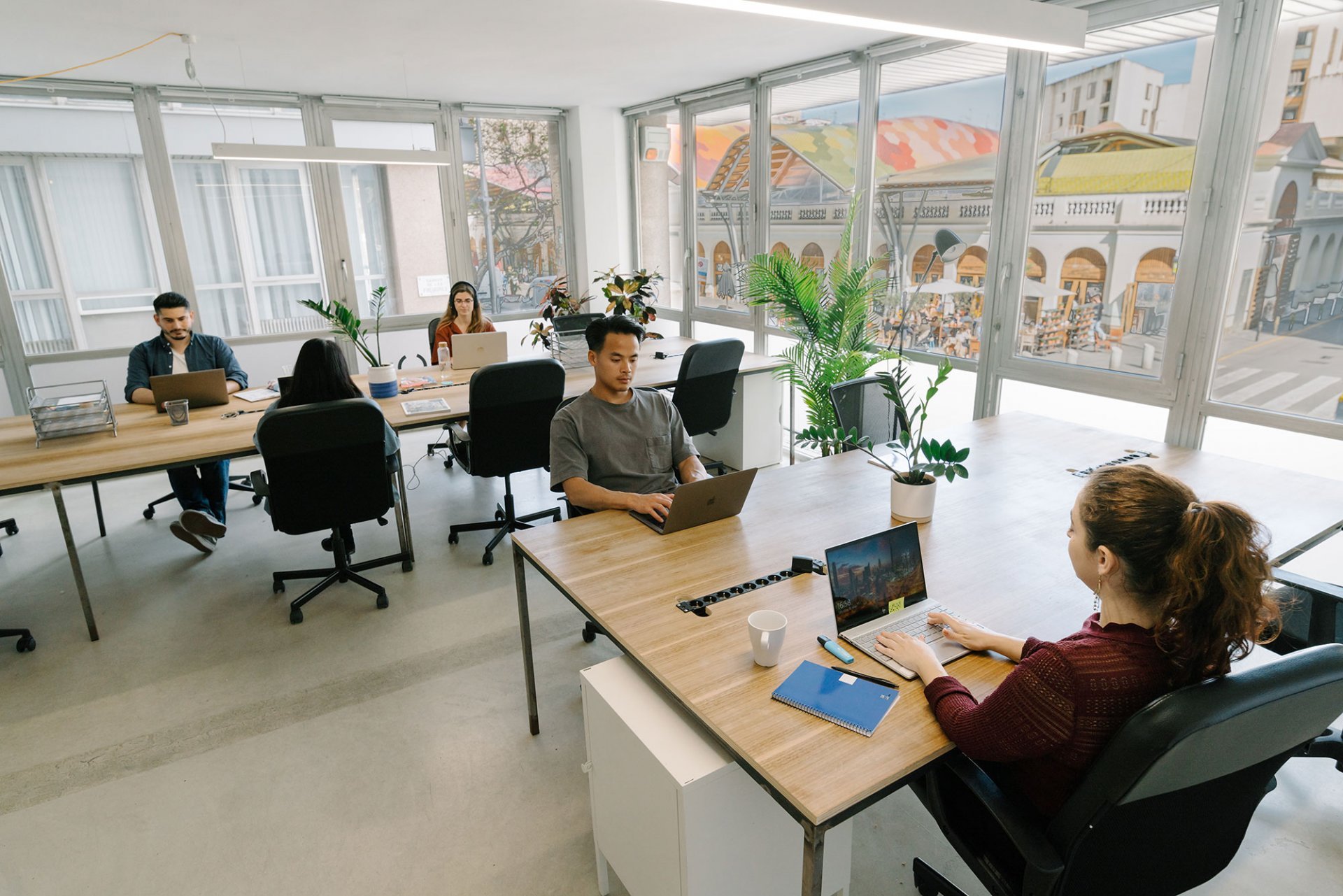 Equipo de una startup trabajando de forma productiva en una oficina luminosa encontrada a través de un proceso de búsqueda eficiente.