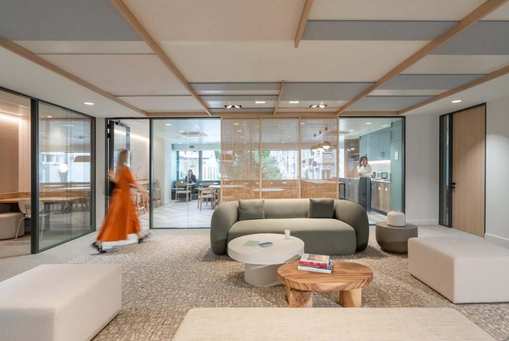 Zona de descanso de una oficina moderna que refleja la cultura de la startup, con un sofá y espacios de colaboración.
