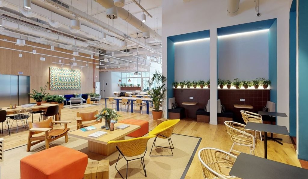 Zona de espacios comunes en un coworking, mostrando distintas áreas de trabajo y descanso, clave en la planificación de una oficina para startup.