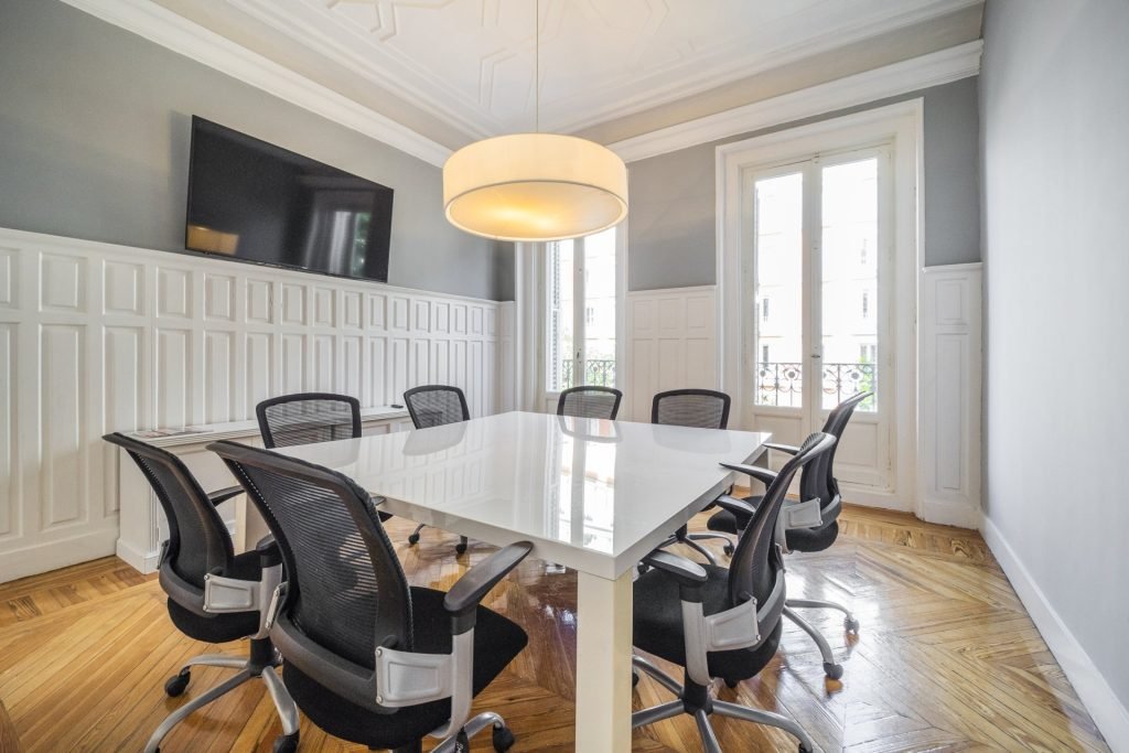 Sala de reuniones clásica donde un comité de startup planifica una mudanza de oficina para garantizar la continuidad operativa.