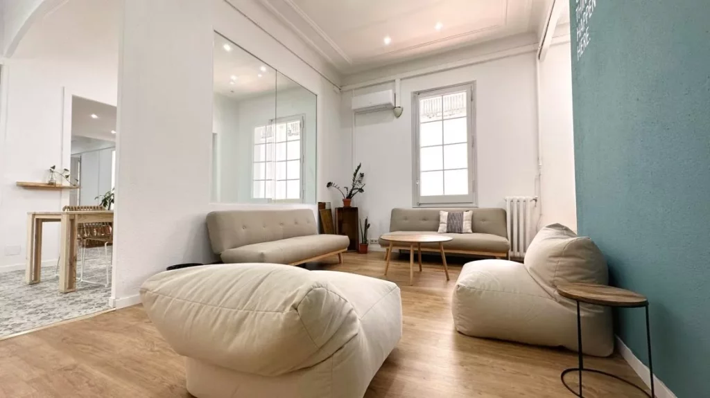 Espacio de descanso acogedor con mobiliario de diseño en las oficinas de Sowo, un entorno boutique en la Dreta de l'Eixample.