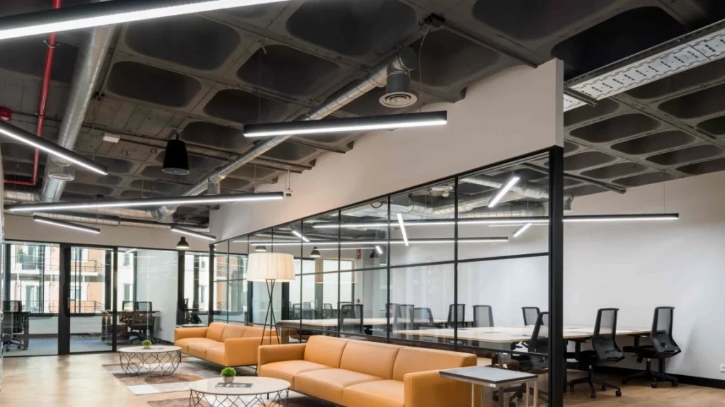 Oficina privada con cerramientos de cristal, iluminación moderna y zona lounge en Venture X Velázquez