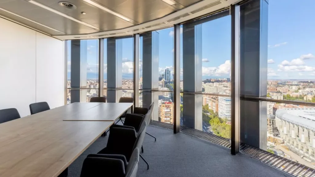 Sala de reuniones ejecutiva en First Torre Europa con vistas panorámicas al estadio Santiago Bernabéu.