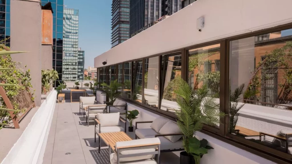 Terraza privada con zonas de descanso en el espacio flexible de Venture X, cerca del eje AZCA-Tetuán.