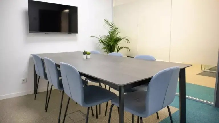 Sala de juntas pequeña y funcional en Cink Ríos Rosas con pantalla para videoconferencias, optimizada para el día a día de una startup tecnológica.