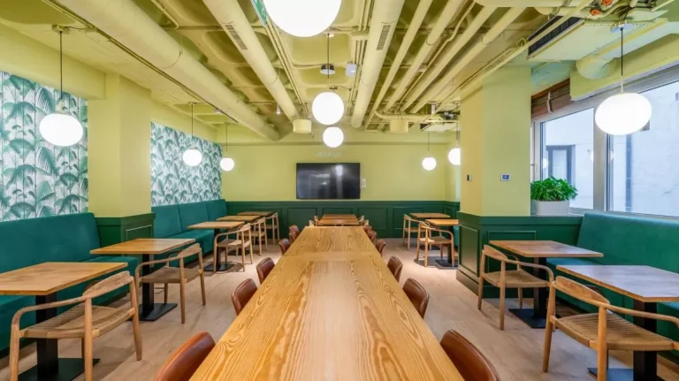 Cantina y área colaborativa con diseño biofílico en Utopicus José Abascal, Madrid, optimizada para fomentar la creatividad y colisiones creativas en el equipo.