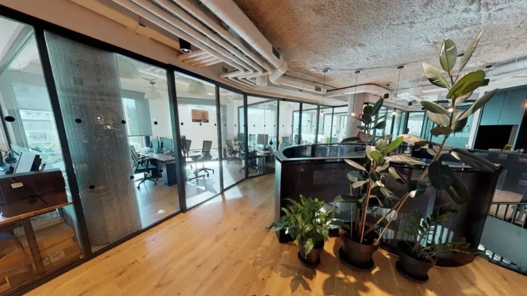 Pasillo de despachos privados acristalados en WeWork Castellana 43 que ofrecen confidencialidad y luz natural para equipos en crecimiento.