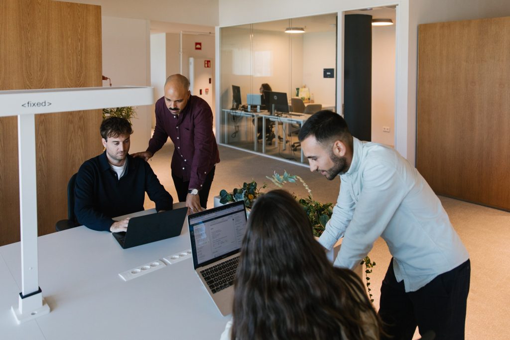 Equipo de una startup colaborando en un espacio abierto equipado con iluminación adecuada y mobiliario funcional.