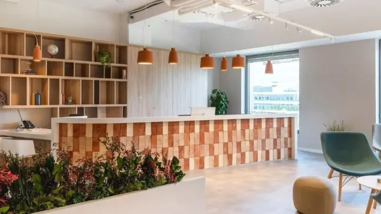 Detalle del mostrador de bienvenida en Lexington La Illa con diseño corporativo en madera y ambiente ejecutivo para grandes empresas.