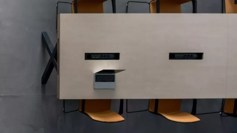 Detalle de mesa de madera con conectividad integrada en una oficina flexible en Arganzuela.