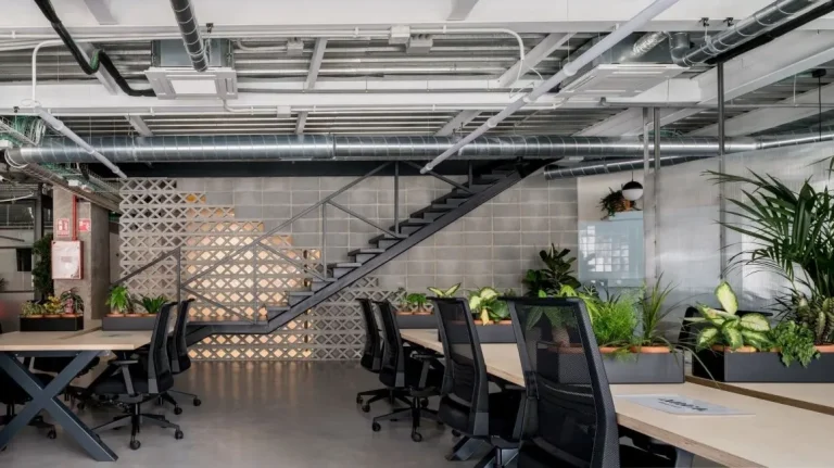 Oficina de estética industrial en Arganzuela con estructuras de metal y branding de Area Coworking.