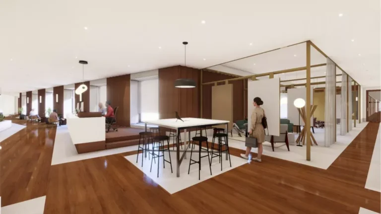 Amplia zona lounge en el coworking Spaces La Illa con mesas altas y áreas de espera para clientes externos.