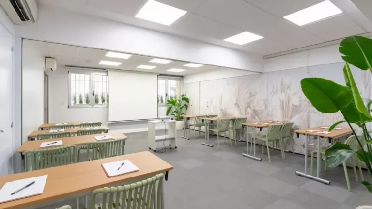 Sala de formación equipada con proyector y puestos individuales en Inspira Workspaces Arganzuela.