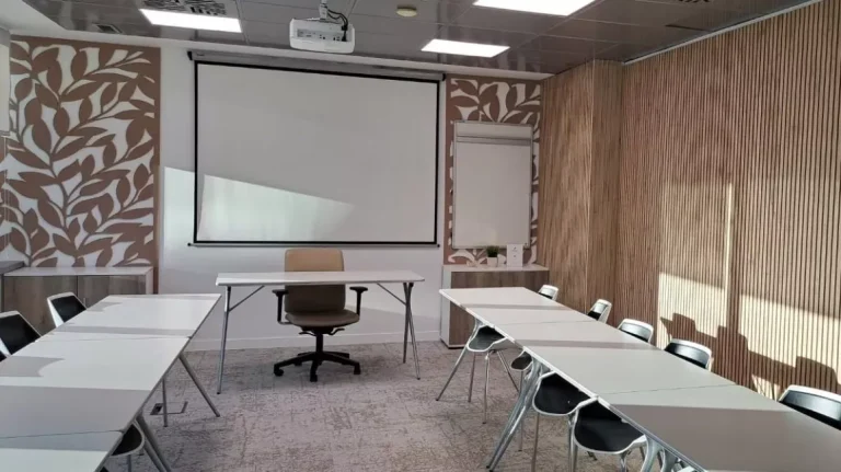 Sala de juntas o formación en Networkia Diagonal equipada con proyector, pizarras y mobiliario modular.
