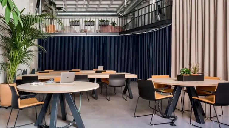 Zona de mesas redondas para networking y reuniones en un coworking de Arganzuela.