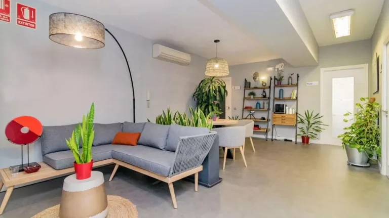 Área común con sofás y vegetación en las oficinas flexibles de Inspira Workspaces en el barrio de Delicias.